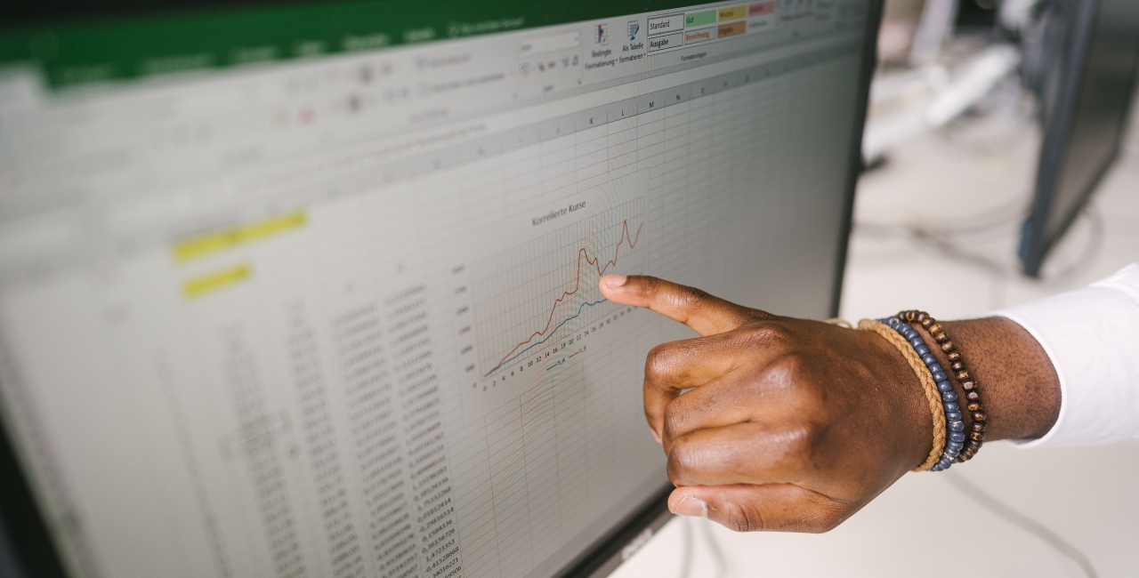 Finger zeigt auf ein Diagramm auf einem Monitor