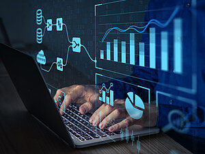 Laptop, im Vordergrund digitale Diagramme